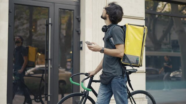 Delivery man who is going and texting on the smartphone