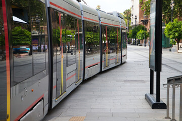 tram arriving at its station to pick up passengers. Travel concept, public transport, renewable...