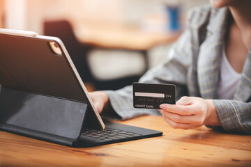 girl holding a credit card and using a laptop Business woman working from home . online shopping, ecommerce, internet banking, spend money, work from home concept.