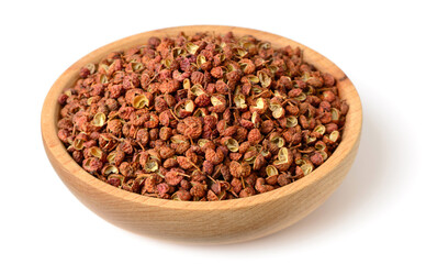 dried Szechuan pepper in the wooden plate, isolated on the white background
