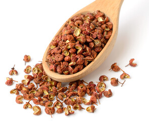 dried Szechuan pepper in the wooden spoon, isolated on the white background