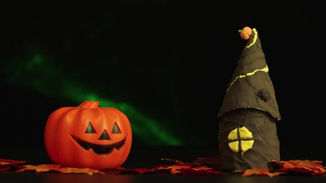 A house and a sinister pumpkin, a Halloween horror story in the dark. Isolated image on black background, copy space. Video, footage or background for splash screen, credits, cutouts, intro. UHD 4K.