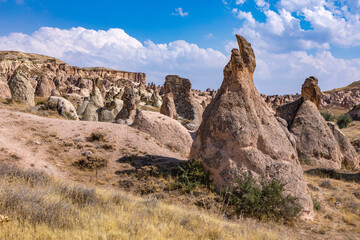 Fototapeta na wymiar Cappadocia, Turkey - September 1, 2021 – Impressive nature by chimney rock formations and rock pillars of “love Valley” near Goreme, Cappadocia, Nevsehir, Turkey
