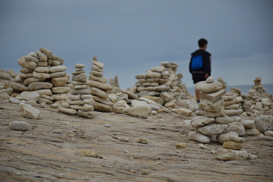 Child meditating while gazing at the horizon from the seashore