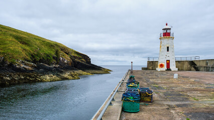 Lybster harbour and Lybster lighthouse with a row of lobster creels - obrazy, fototapety, plakaty