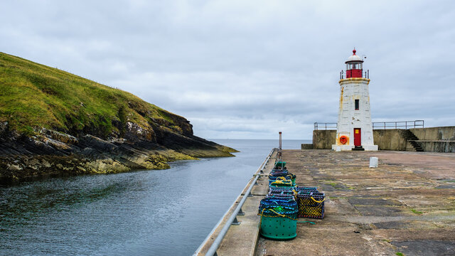 Lybster harbour and Lybster lighthouse with a row of lobster creels