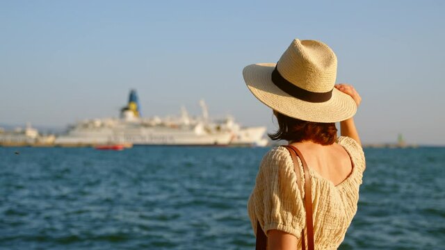 Young woman in hat looking at the sea. Split, Croatia