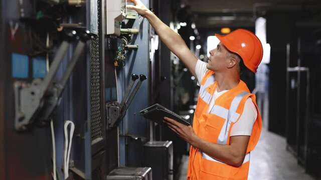 Engineer using digital tablet checking and inspecting at MDB panel. They working with electric switchboard to check range of voltage working in main distribution boards factory