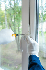 The wizard installs the handle on the plastic window. close-up, selective focus