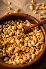 Wheat flakes cereal breakfast in wooden bowl on the rustic background. Selective focus.