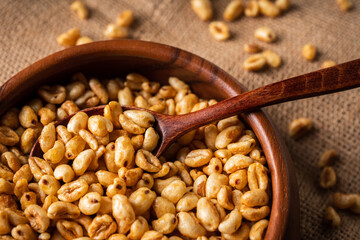 Wheat flakes cereal breakfast in wooden bowl on the rustic background. Selective focus.