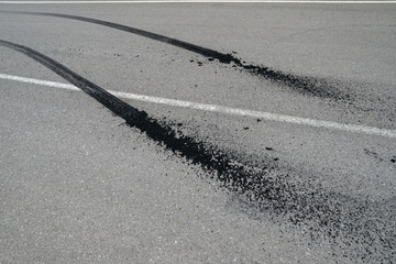 Close-up view of burnt rubber tracks on the asphalt with white markings.
