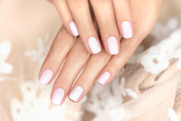 Beautiful female hands with gentle pink manicure. Beautiful manicure with openwork nail art.