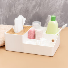 Plastic organizer for bathroom accessories. Сontainer box with towel, shampoo and toothbrush. Square
