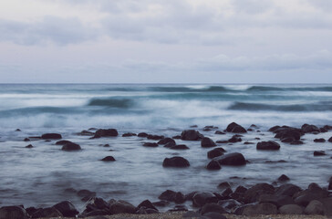 waves on the beach with a rocky shore
