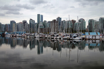 Fototapeta na wymiar Dramatic reflections of the boats and skyscrapers of Vancouver marina