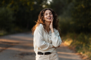 Charming girl with curly hair and a white smile wearing a fashionable fall sweater