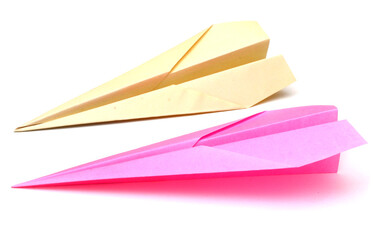 Pink and yellow paperplanes on a white background