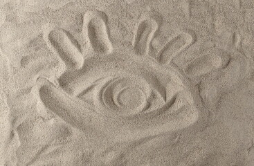 Hand drawn symbol eye in desert sand background and texture