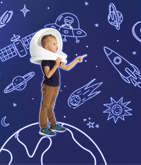 Creative artwork with little boy in huge white astronaut helmet standing among drawn planets,...
