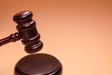 Gavel down on stand on brown background. Justice of law system conceptual.