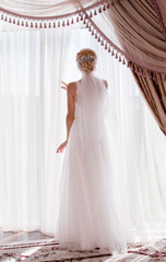 The bride stands at the window