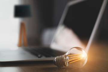Laptop and glowing light bulb. Self learning or education knowledge and business studying concept. Idea of learning online or e-learning from home.