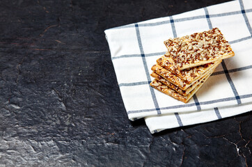 Crisp bread with seeds. Crunchy crispbread on a wooden background. Healthy snack: cereal crunchy multigrain cereal flax seed, sunflower seeds protein bread bar