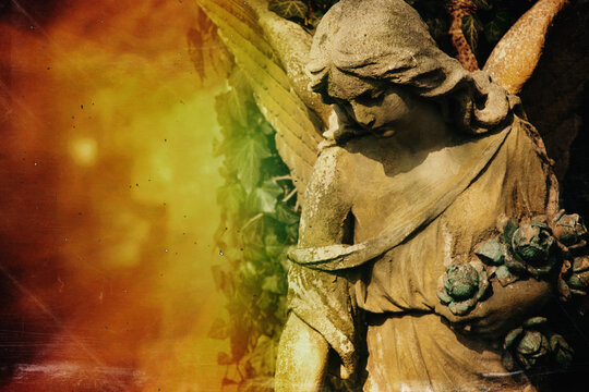 An ancient statue of guardian angel (vintage style photo). Copy space.