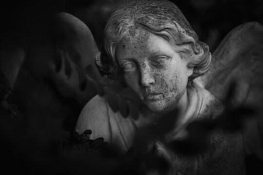 Death. Statue of an angel as symbol of pain, fear and end of life. Black and white image.