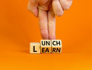 Lunch and learn symbol. Businessman turns wooden cubes and changes a concept word 'lunch' to 'learn' on a beautiful orange background. Copy space. Business, educational and lunch and learn concept.
