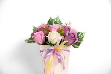 Bouquet of beautiful bright rose flowers in a gift cylindrical cardboard box. Bouquet of soap on a white background	