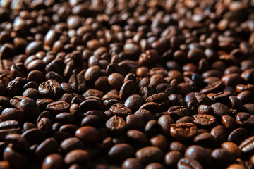 Dark roast coffee beans background. Big pile of roasted espresso seeds in close up