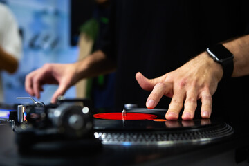 Hip hop dj scratching vinyl records on stage. Professional disc jockey scratches analog record with...