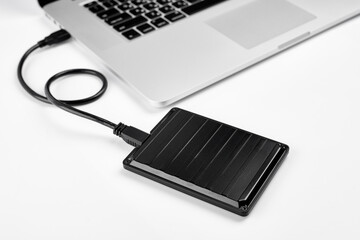 An external USB hard disk drive isolated on a white background. External Hdd drives and flash drives. External hard disk drive for connect to laptop, transfer or backup data between computer and HDD. - obrazy, fototapety, plakaty