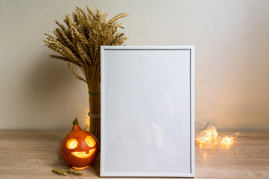 Portrait frame mock up with dried flowers pumpkin on wooden table. halloween