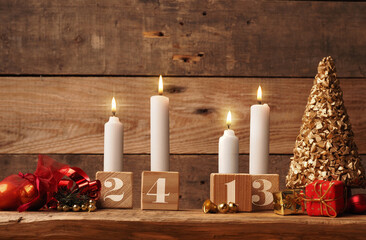 Fourth Advent, four candles burning on a rustic wooden table with Christmas decoration