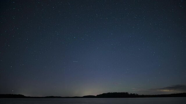 Timelapse of stars motion above a lake. Night sky time-lapse.