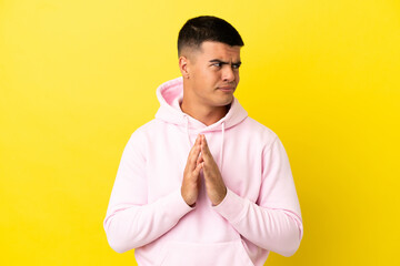 Young handsome man over isolated yellow background scheming something