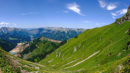 Naklejka premium hiking path over a green steep mountain with view to the ore mountain in styria austria