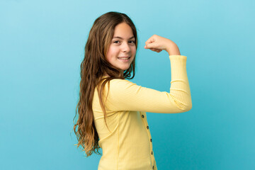 Little caucasian girl isolated on blue background doing strong gesture