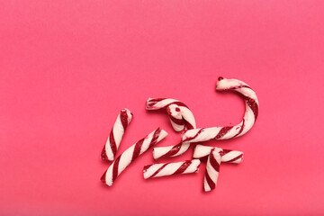 Broken candy cane and space for text on color background, top view