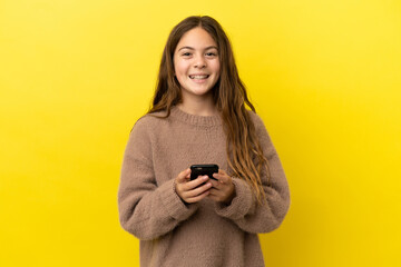 Little caucasian girl isolated on yellow background surprised and sending a message