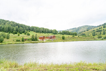wooden house on the lake shore in the mountains, recreation center by the lake, cottages on the shore of a picturesque lake, rest in a country house by the water