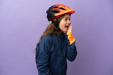 Little caucasian girl isolated on purple background shouting with mouth wide open to the side