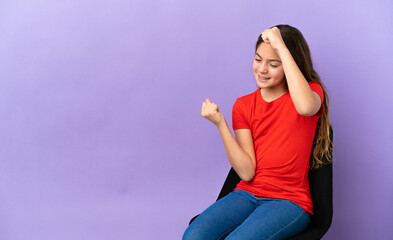 Little caucasian girl sitting on a chair isolated on purple background celebrating a victory