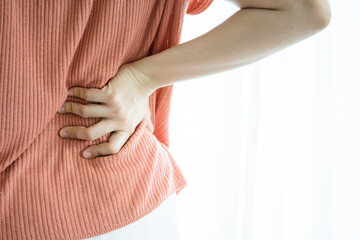 Asian young woman feels backache after doing a house work for a while.