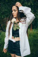 Belle fille avec une rose blanche en vêtements