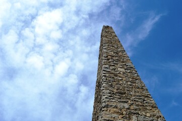 large stone pillar and clouds