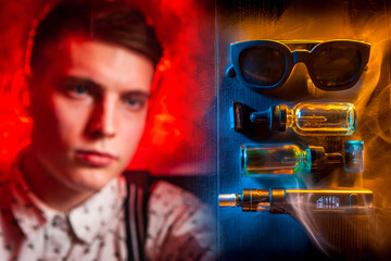 Vaper. Smoking liquids and vapes. Concept - vaping. Gadgets for vapers on a dark background. Young guy next to the vape pen. Smoke. Smoking electronic cigarettes. Vaping shop. Vaping accessories.